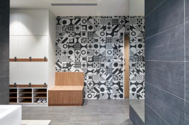 Novaptus Surgery Centre, in contrast to the polished glass colours of operating theatres, the surgeon's change room uses predominantly black and grey finishes, incorporating patterns and textures.